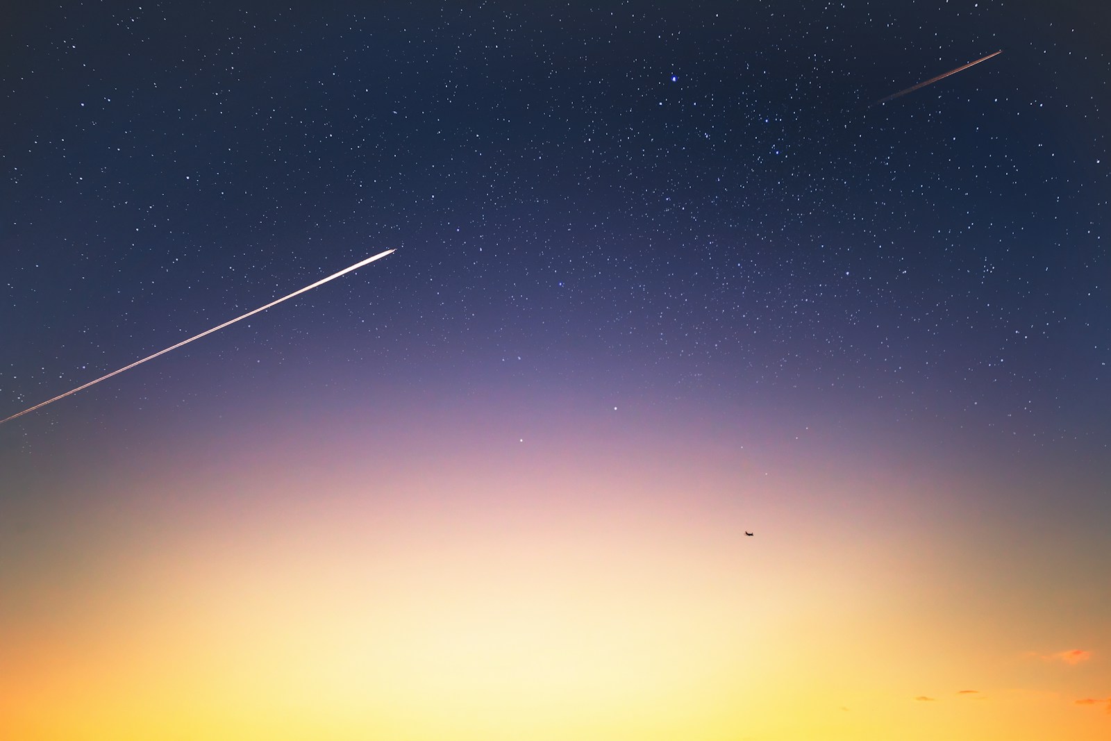 Starry night with shooting stars and a bright sunrise.