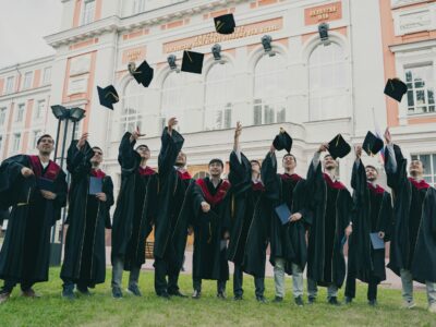 a group of people in graduation gowns holding their caps up